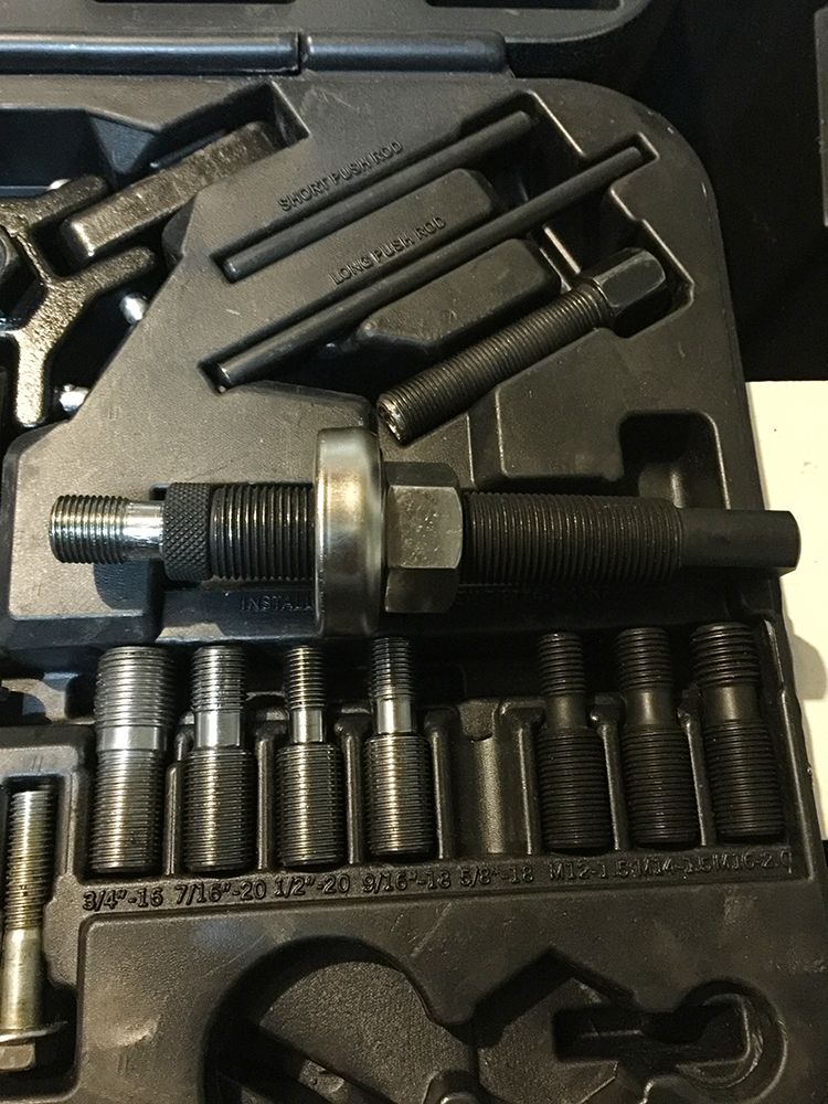 Automotive pulley puller tool kit with various adapters and rods. Includes short and long push rods