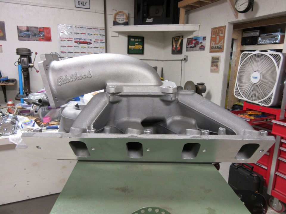 Edelbrock intake manifold on a workbench in a garage