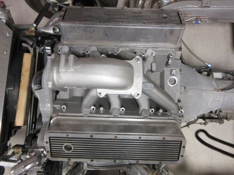 Close-up of an engine block with aluminum intake manifold and finned valve covers