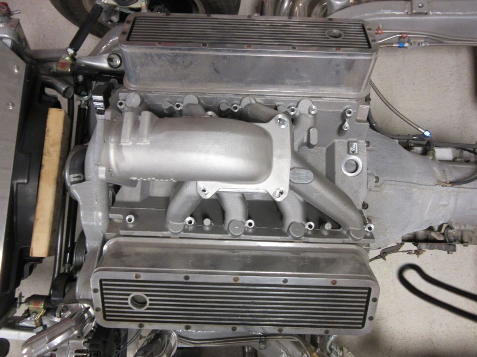 Close-up of an engine block with aluminum intake manifold and finned valve covers