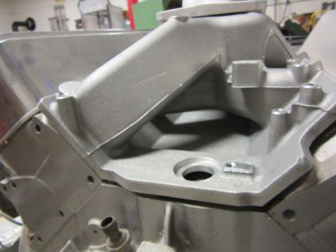 Aluminum intake manifold with a silver finish, showing internal passages and mounting holes