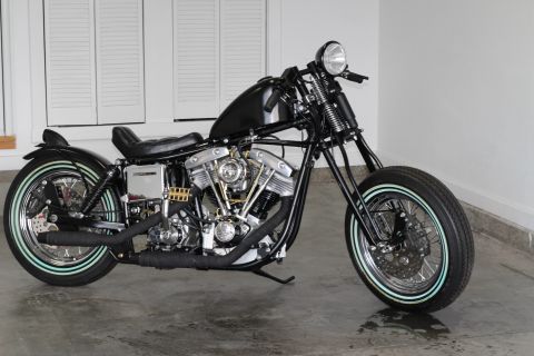 1975 Harley-Davidson FXRT Sport Glide - A custom black motorcycle with whitewall tires is parked indoors, its engine and frame.