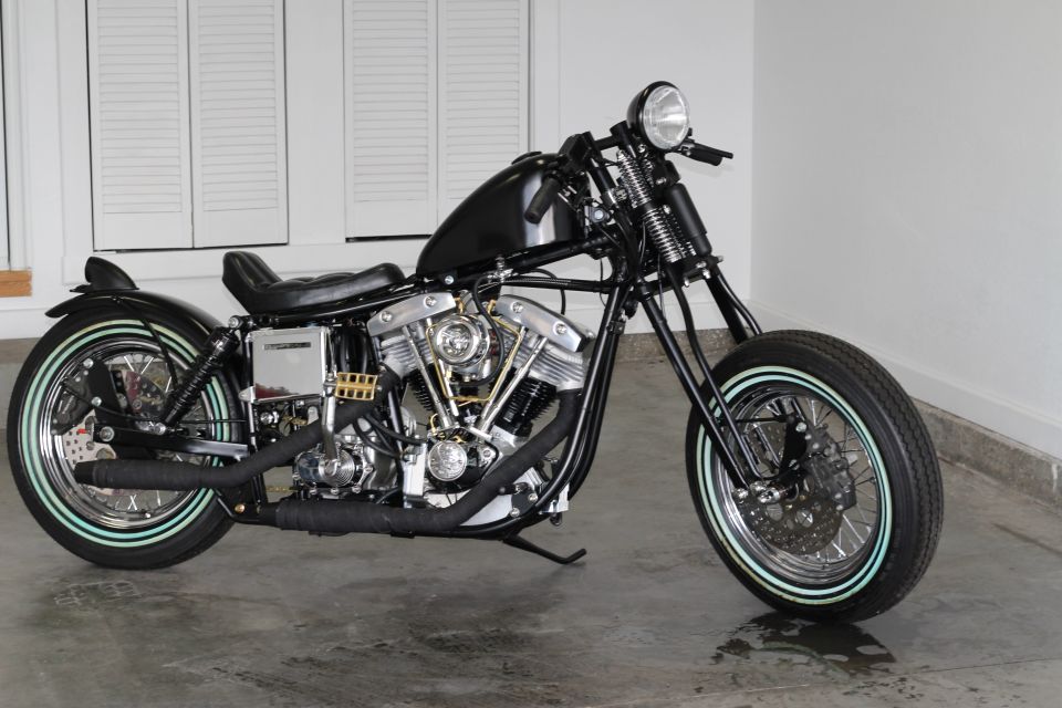 Black custom motorcycle with whitewall tires and exposed engine
