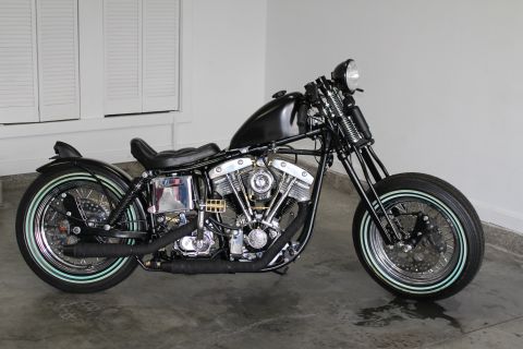 1975 Harley-Davidson FXRT Sport Glide - A black motorcycle is shown from the side, whitewall tires and exposed engine components.