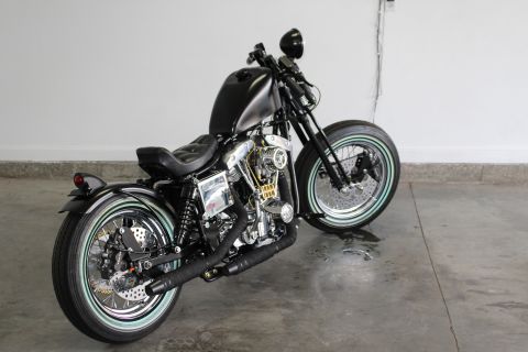 1975 Harley-Davidson FXRT Sport Glide - Custom motorcycle with a black fuel tank and seat, parked indoors.