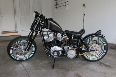 1975 Harley-Davidson FXRT Sport Glide - A custom motorcycle is parked in a garage with fishing rods mounted on the wall behind it.