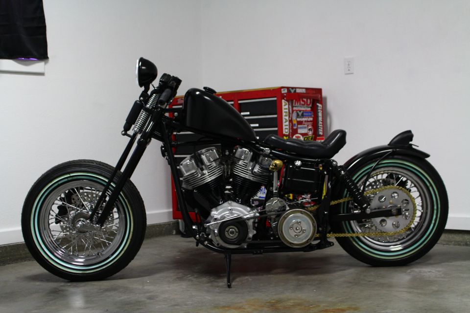 Side view of a black custom motorcycle with whitewall tires and a V-twin engine