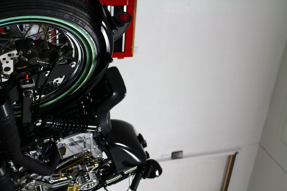 Close-up of a black motorcycle's front wheel, engine, and fairing