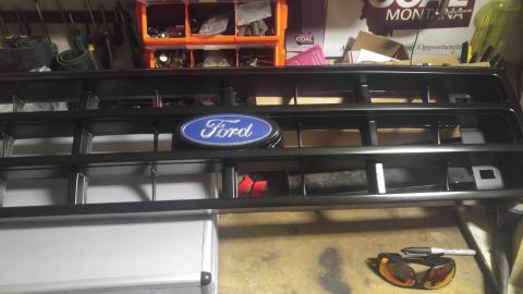 1991 Ford Bronco - A close-up view of a Ford emblem on a vehicle's front grille, likely for a restoration project.