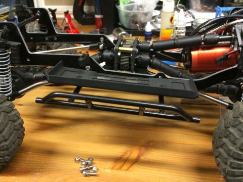 1989 Ford Bronco - Close-up view of an RC car's internal components, including the motor and drivetrain, on a workbench.