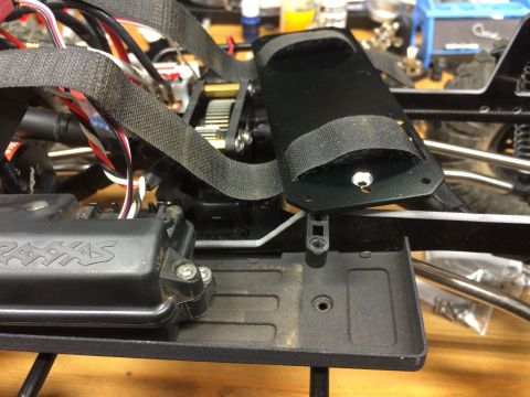 1989 Ford Bronco - Close-up of an RC car chassis, showing the 'TRAXXAS' electronics box, wiring, and securing straps.