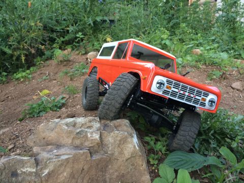 1989 Ford Bronco - This RC Bronco features a classic body style and off-road tires, navigating a rocky terrain.