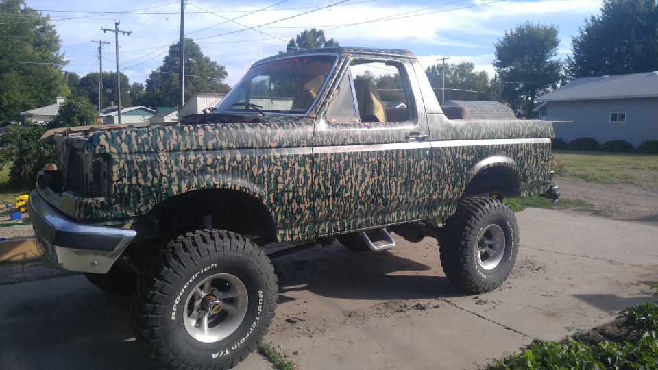 Lifted Ford Bronco with camouflage wrap, parked outside
