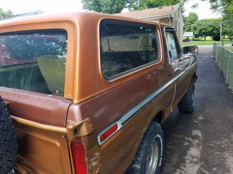 1979 Ford Bronco - This 1979 Ford Bronco is seen from the rear quarter angle, showing its classic brown exterior and spare tire mount.