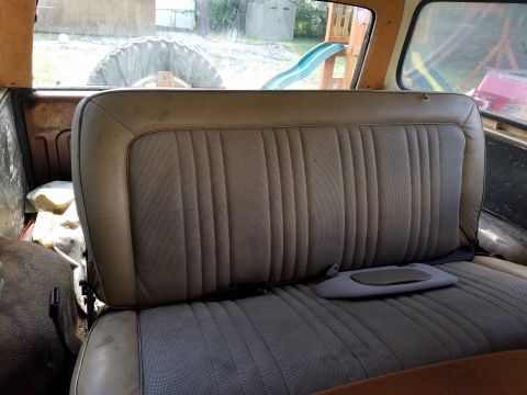1979 Ford Bronco - Rear interior view of a vehicle, showing the bench seat and a spare tire mounted outside.