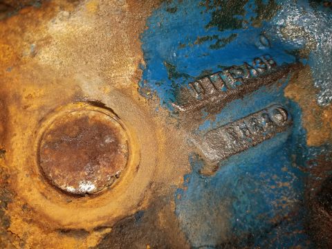 1979 Ford Bronco - Close-up of a cast iron engine component with visible casting numbers and signs of wear and repainting.
