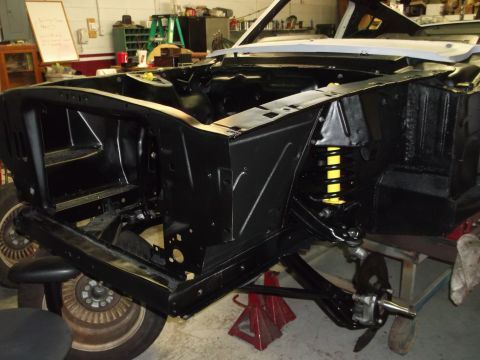 1967 Ford Mustang - The front end of a 1967 Ford Mustang is shown during a restoration project, with the chassis and suspension components visible.