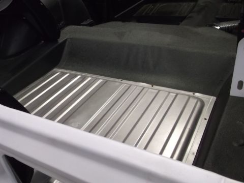 1967 Ford Mustang - The trunk interior shows a ribbed metal floor and carpeted side panels.