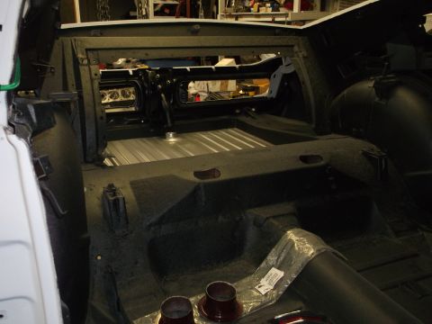 1967 Ford Mustang - The interior of a vehicle undergoing restoration, revealing its bare floor and structural components.