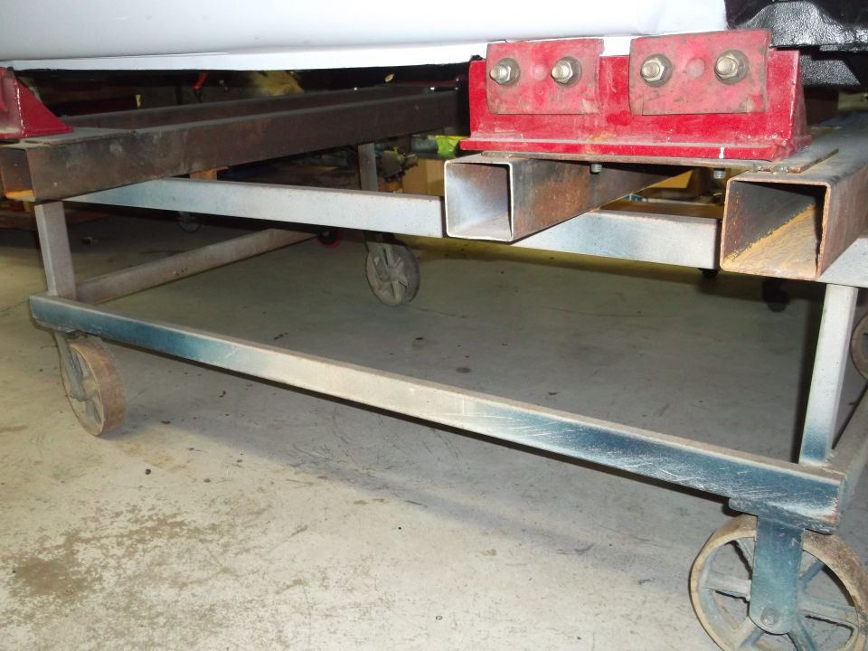 Car body supported by a metal dolly with red brackets