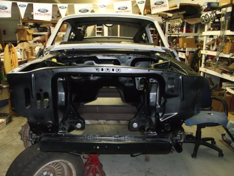 1967 Ford Mustang - This vehicle is undergoing restoration in a workshop, with its front end completely stripped down.