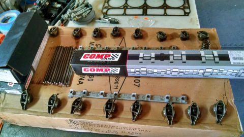 1985 Jeep CJ7 - Various engine components, including rocker arms and pushrods, are organized on a cardboard box.