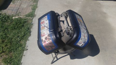 1991 Ford Bronco - Two tail lights, taped and covered with newspaper, sit on a table outdoors.