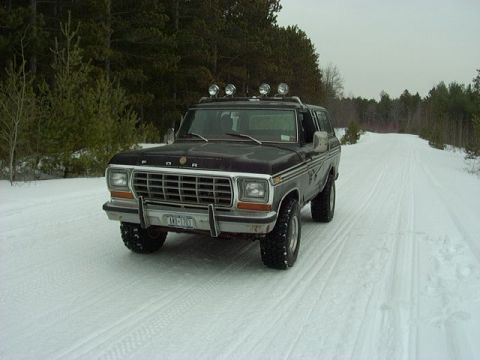 1978 Ford Bronco - This 1978 Ford Bronco is driving on a snow-covered road through a wooded area.