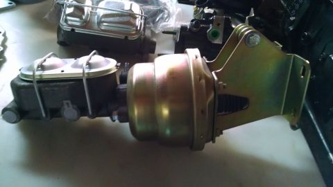 1985 Jeep CJ7 - A close-up view of a brake booster and master cylinder assembly, with another master cylinder in the background.