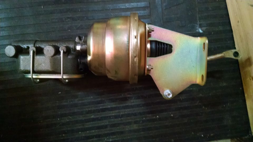 Brake booster and master cylinder assembly with gold and black finish, mounted on a dark surface