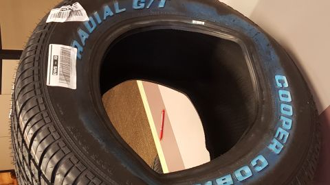 1973 Ford F-100 - Close-up of a Cooper Radial G/T tire, showing brand name and a sticker with text.