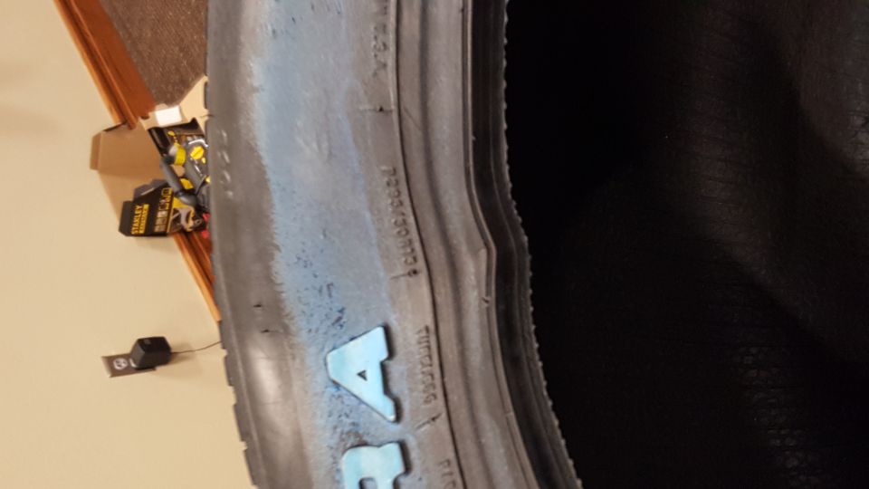 Tire sidewall with blue lettering and tire size information