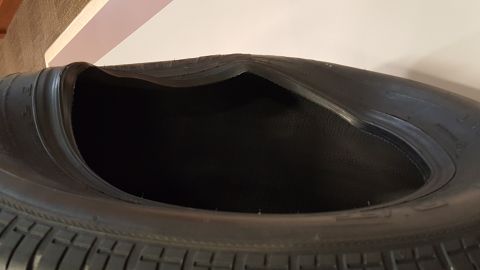 1973 Ford F-100 - This tire has suffered significant damage, with a large portion of its sidewall compromised and collapsed.