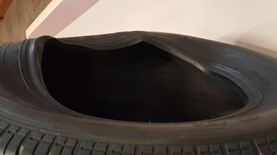 Damaged tire with a large section of the sidewall collapsed inward