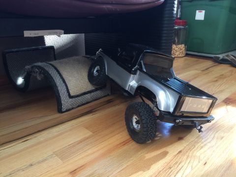 1989 Ford Bronco - A remote-controlled truck navigates an obstacle course on a wooden floor.