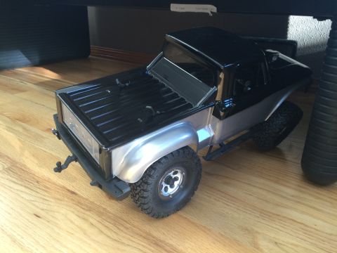 1989 Ford Bronco - A toy truck with a black bed and cab sits on a wooden floor.