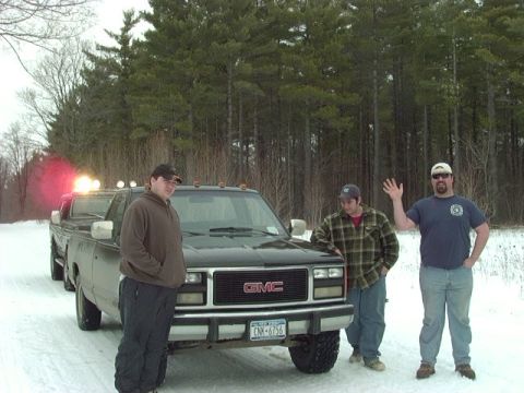 1978 Ford Bronco - A group of friends pose with their GMC pickup trucks in a snowy, wooded area.