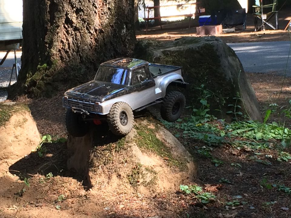 RC truck with silver body and black roof on dirt mound
