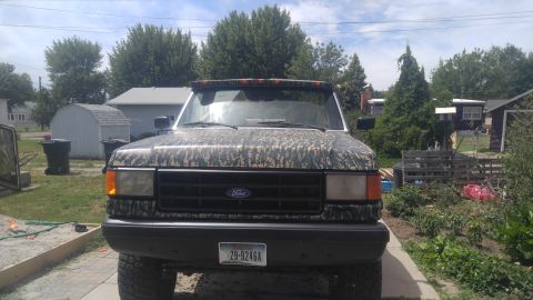 1991 Ford Bronco - This 1991 Ford Bronco is seen from the front, a camouflage wrap and an aftermarket light bar above the windshield.