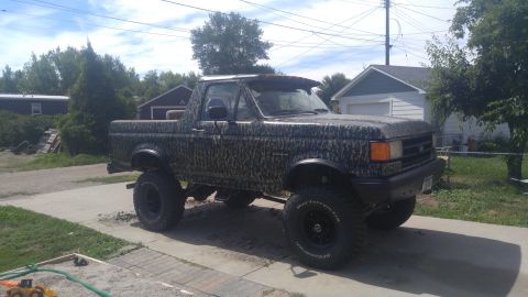 1991 Ford Bronco - This lifted Ford Bronco features a camouflage wrap and sits high on off-road tires.