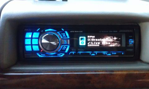 1996 Ford Bronco - Close-up of a car's dashboard stereo system with glowing blue accents and an iPod connection.