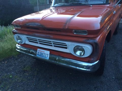 1962 Chevrolet Suburban - Front view of an orange truck, likely from the early 1960s, with a white grille and chrome bumper.