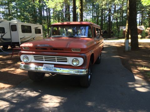 1962 Chevrolet Suburban - This vintage Chevrolet Suburban, likely from the early 1960s, is seen parked outdoors with a trailer nearby.