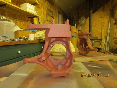 1986 Ford Bronco - Two red-painted Dana 60 axle knuckles are shown in a workshop setting.