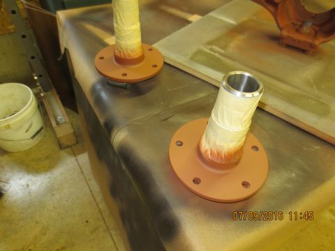 1986 Ford Bronco - Axle shafts are prepared for painting in a workshop setting.