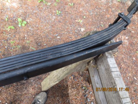 1986 Ford Bronco - Close-up of vehicle leaf springs supported by wood, with a date stamp in the corner.