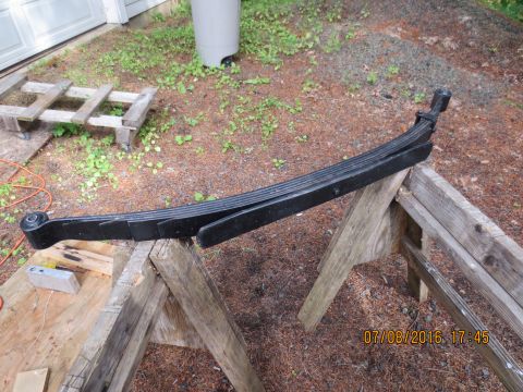 1986 Ford Bronco - A single leaf spring is displayed outdoors on sawhorses, with a timestamp in the corner.