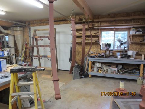 1986 Ford Bronco - Leaf springs are being worked on in a workshop setting with various tools and equipment visible.
