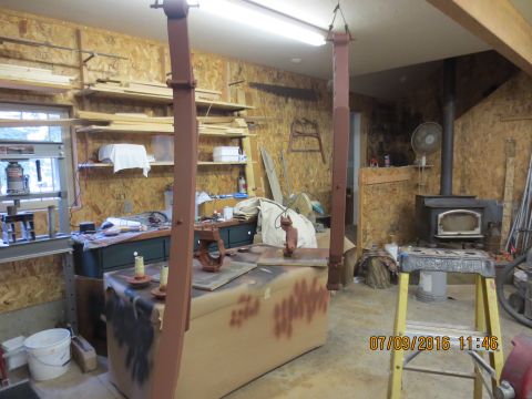 1986 Ford Bronco - Interior view of a workshop a car lift, wood-burning stove, and various tools and supplies.