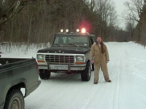 1978 Ford Bronco - Man stands by a 1978 Ford Bronco in a snowy landscape, with another vehicle in the foreground.